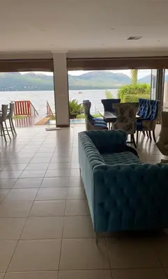 a living room with a blue couch and a table and chairs at Dam View HOUSE in Hartbeespoort