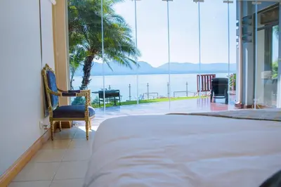 a bedroom with a bed and a view of the water at Dam View HOUSE in Hartbeespoort