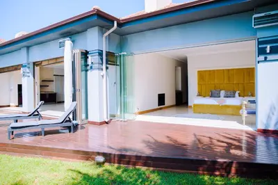 a house with a glass extension with a bed at Dam View HOUSE in Hartbeespoort