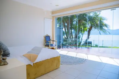 a bedroom with a bed and a large window at Dam View HOUSE in Hartbeespoort