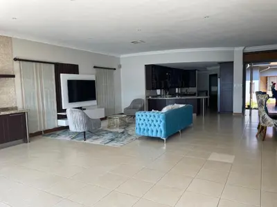 a living room with a blue couch and chairs at Dam View HOUSE in Hartbeespoort