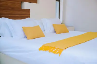 a white bed with two pillows and a blanket on it at Dam View HOUSE in Hartbeespoort