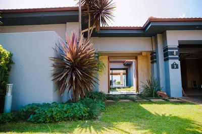 a house with a palm tree in front of it at Dam View HOUSE in Hartbeespoort