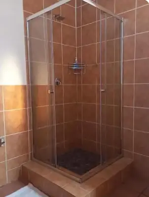 a shower with a glass door in a bathroom at Lime Court One in Pretoria