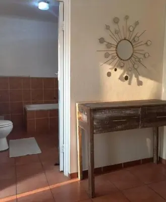 a bathroom with a toilet and a clock on the wall at Lime Court One in Pretoria