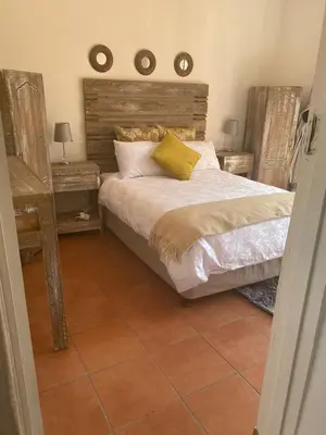 a bedroom with a bed with a wooden headboard at Lime Court One in Pretoria