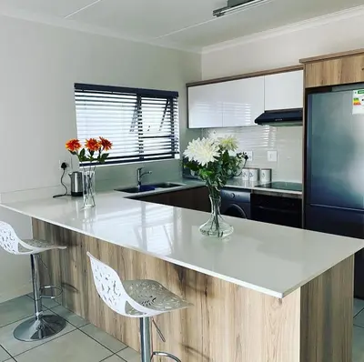 a kitchen with a counter with vases of flowers on it at The Blyde Magna Host Luxury Apartments in Pretoria
