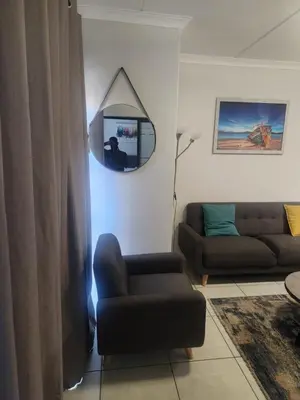 a living room with a couch and a mirror at The Blyde 1317 in Pretoria
