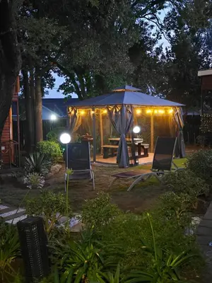a tent with chairs and a table in a yard at night at Halfway Gardens Home in Midrand