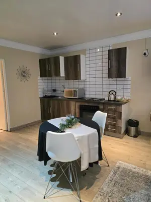 a kitchen with a table and chairs in a room at Halfway Gardens Home in Midrand