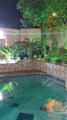 a swimming pool in a garden at night at Halfway Gardens Home in Midrand