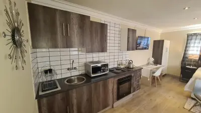 a kitchen with a sink and a microwave at Halfway Gardens Home in Midrand