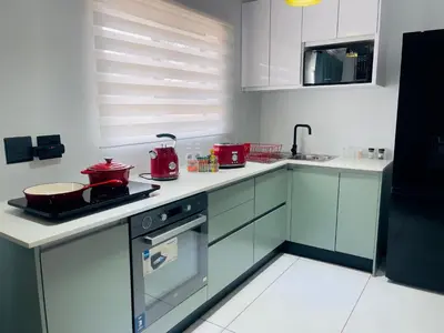 a kitchen with white cabinets and red appliances at ANG COMSAT Guesthouse in Northam