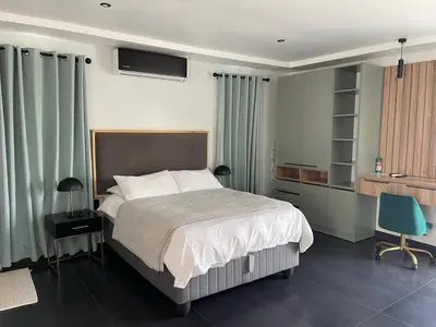 a bedroom with a bed and a desk and a chair at ANG COMSAT Guesthouse in Northam
