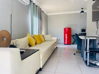 a living room with a white couch with yellow pillows at ANG COMSAT Guesthouse in Northam