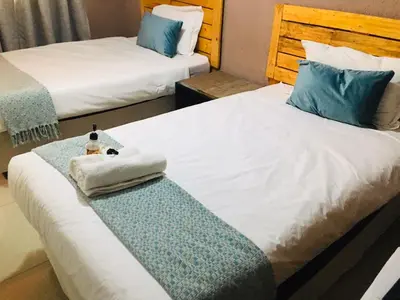 a hotel room with two beds with towels on the bed at Asante’s Guest House in Calcutta