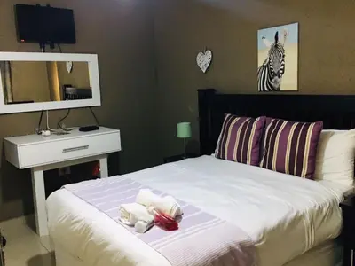 a bedroom with a bed with two stuffed animals on it at Asante’s Guest House in Calcutta