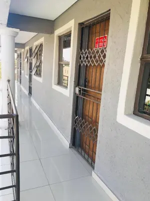 a hallway of a building with a wooden door at Asante’s Guest House in Calcutta