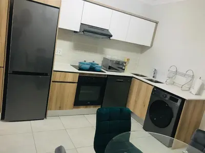 a kitchen with a black refrigerator and a dishwasher at The blyde Pretoria unit 1244 in Pretoria