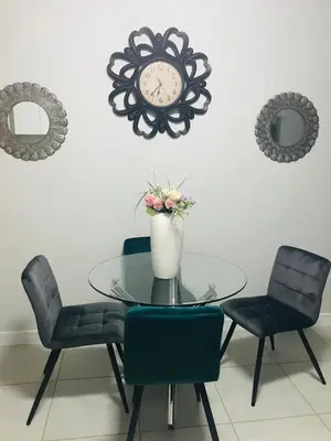 a dining room table with chairs and a clock on the wall at The blyde Pretoria unit 1244 in Pretoria