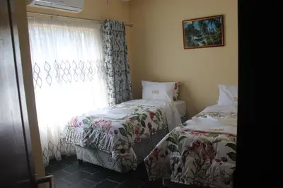 a bedroom with two beds next to a window at Lalamnandzi3 in Nelspruit
