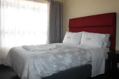 a bedroom with a large bed with a window at Lalamnandzi3 in Nelspruit