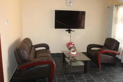a living room with two chairs and a table and a tv at Lalamnandzi3 in Nelspruit