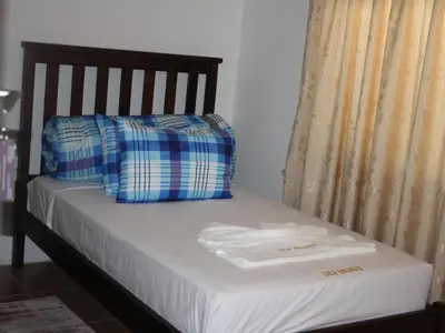 a bed with two pillows and towels on it at Lalamnandzi1 in White River
