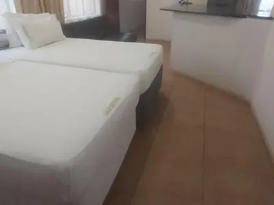 a bedroom with a white bed and a couch at Lalamnandzi1 in White River