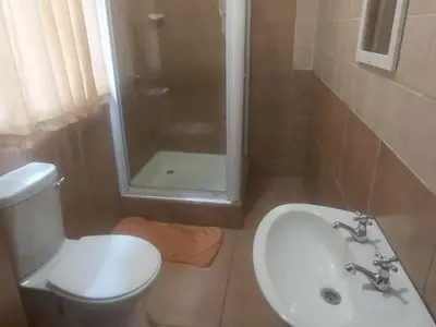 a bathroom with a toilet and a sink and a shower at Lalamnandzi1 in White River