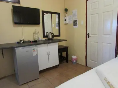 a room with a counter with a tv and a refrigerator at Lalamnandzi1 in White River