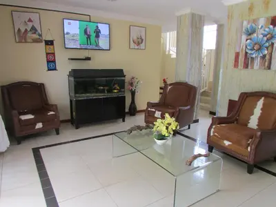 a living room with chairs and a table and a tv at Lalamnandzi2 in White River