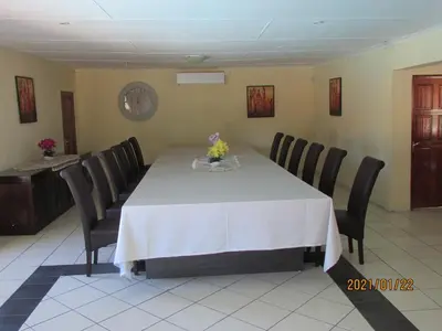 a dining room with a white table and black chairs at Lalamnandzi2 in White River