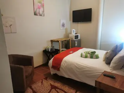 a hotel room with a bed and a television at Sun Deck Lodge in Hartbeespoort