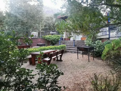 a picnic table and a grill in a garden at Sun Deck Lodge in Hartbeespoort