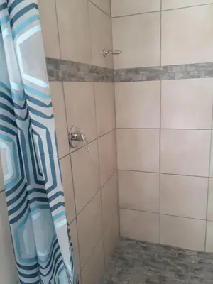 a shower with a blue and white shower curtain at Ruros Guest House in Kempton Park