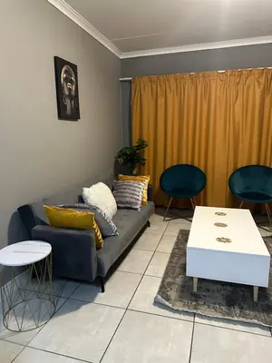 a living room with a couch and two chairs at The Blyde Boutique Apartments in Pretoria