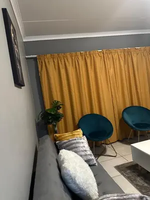 a living room with a couch and two chairs at The Blyde Boutique Apartments in Pretoria