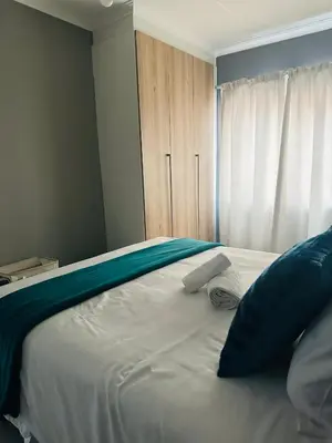 a large white bed with two pillows on it at The Blyde Boutique Apartments in Pretoria