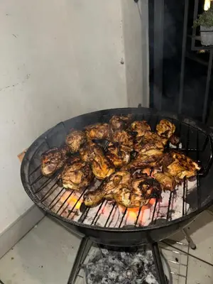 a bunch of chicken cooking on a grill at The Blyde Boutique Apartments in Pretoria