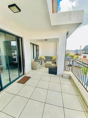 a living room with a couch and a balcony at The Blyde Boutique Apartments in Pretoria