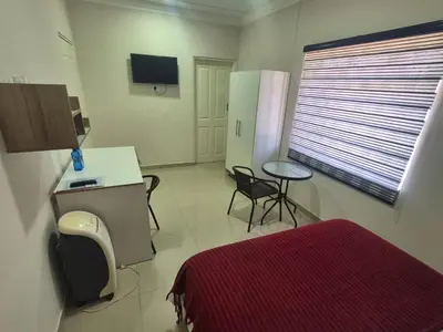 a room with a bed and a table and a window at Ithonsi Guesthouse in Kempton Park