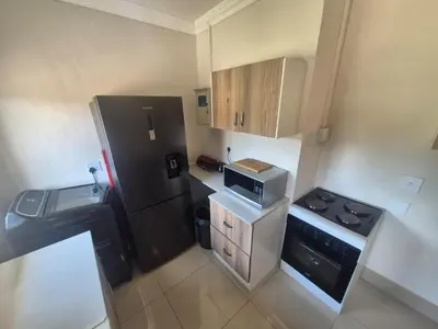 a small kitchen with a black refrigerator and a sink at Ithonsi Guesthouse in Kempton Park