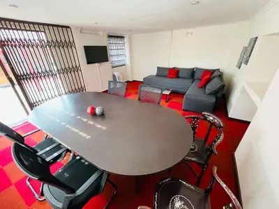 a living room with a table and a couch at Ithonsi Guesthouse in Kempton Park