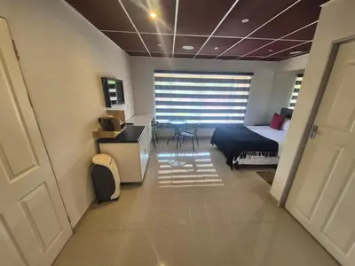 a bedroom with a bed and a desk and a window at Ithonsi Guesthouse in Kempton Park