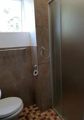 a bathroom with a shower with a toilet and a window at Rand Self-catering Accommodation in Carolina