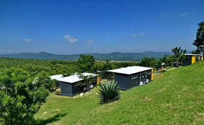 a green hill with two small buildings on it at SleepOver KMIA in White River