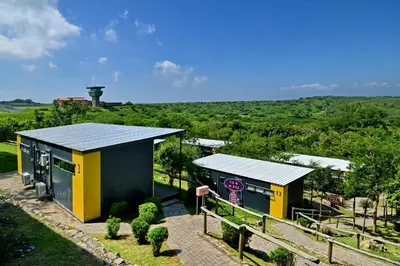 a small yellow and black building with a hill in the background at SleepOver KMIA in White River