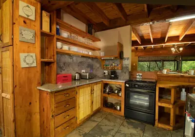 a large kitchen with wooden cabinets and a stove at Adventure Bush Villa in Marloth Park