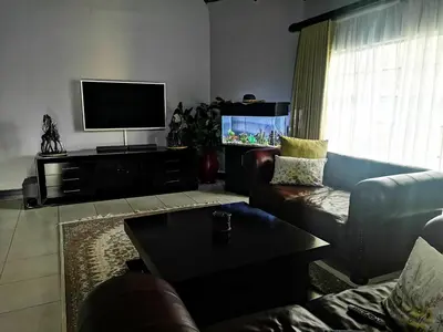 a living room with a couch and a flat screen tv at Sasavona Game Lodge in Warmbaths